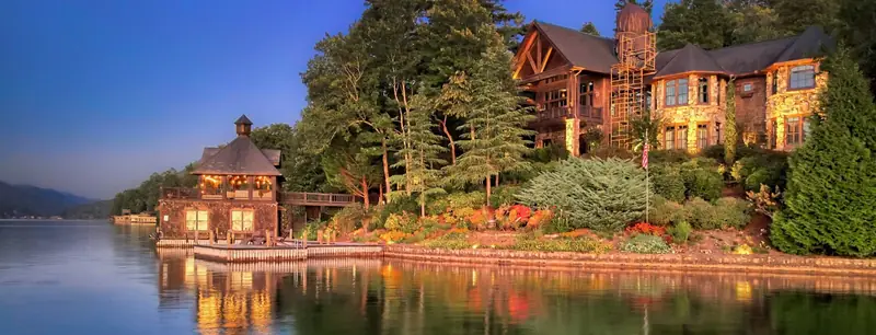 Lake Burton home at sunset with a lit boathouse and landscape lighting