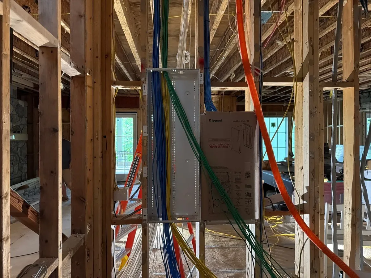 Low-voltage enclosure in open framing with network and speaker cable runs landing in it