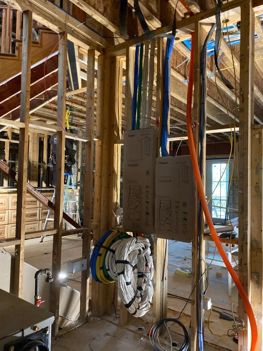 Bundled low-voltage cables running through framing to a wall location during rough-in