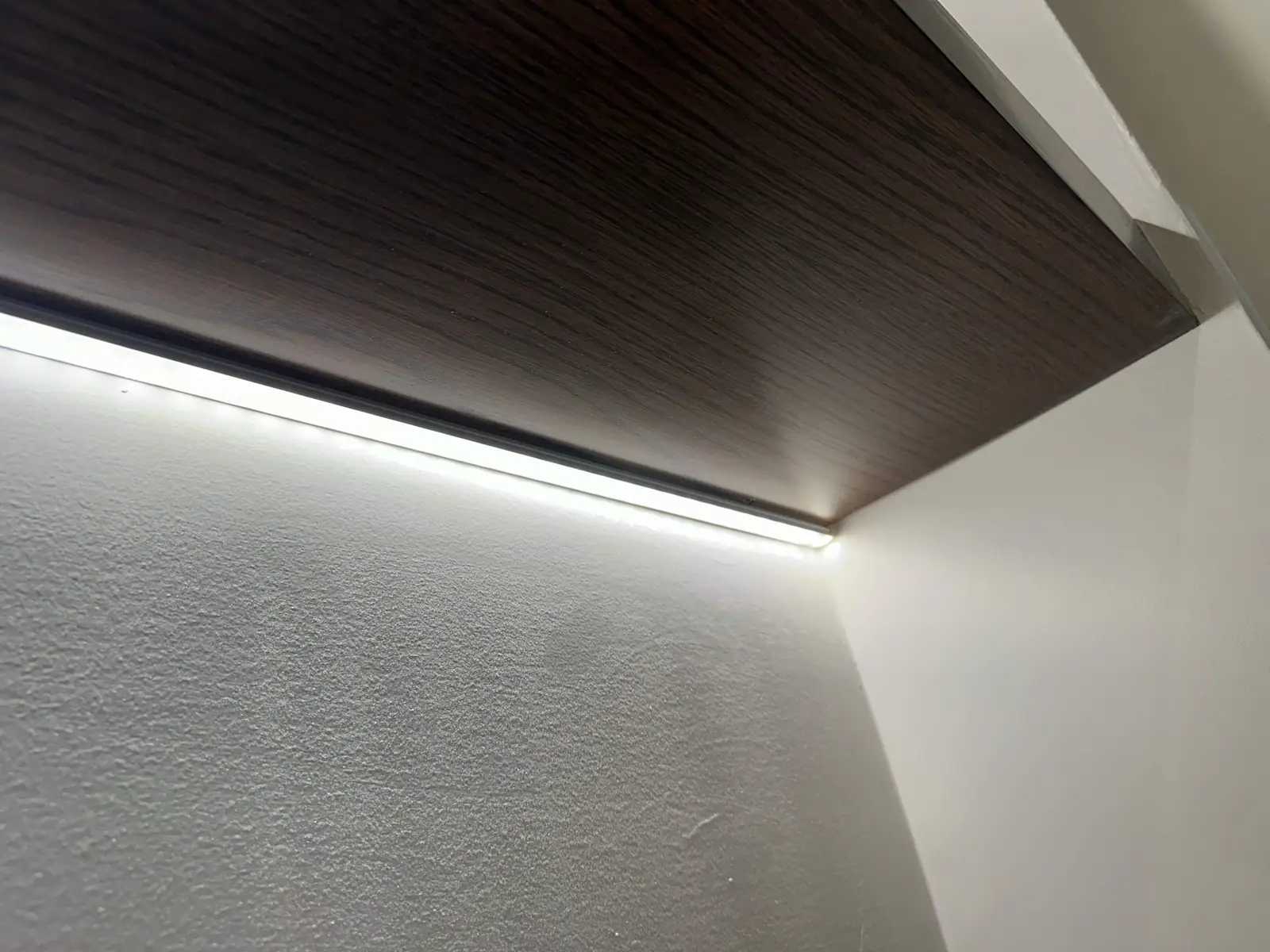 LED cove lighting along a dark wood ceiling in an Atlanta home
