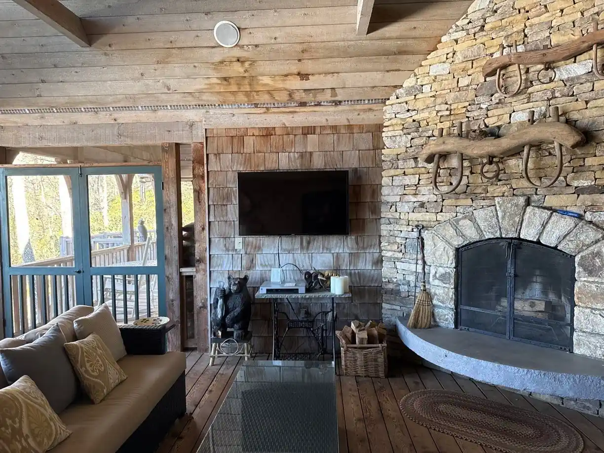 TV above a floor-to-ceiling stone fireplace in a Cashiers NC great room