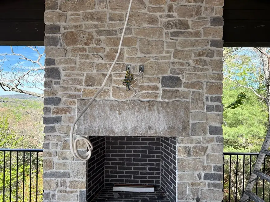Stone porch fireplace prepared for an outdoor TV