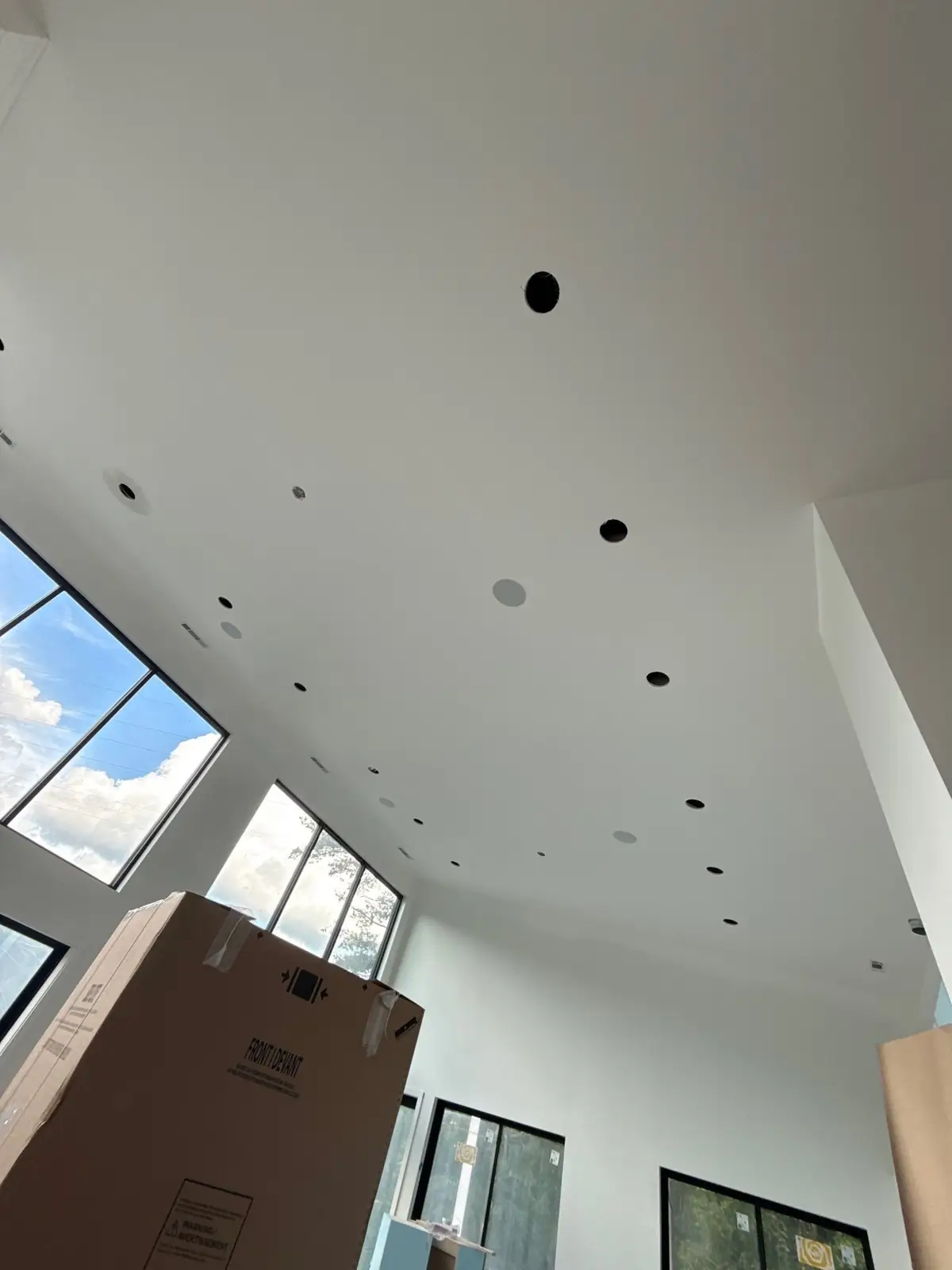 Two-story living space with window walls, ready for audio trim